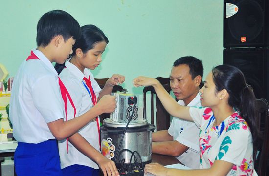 Hồng Thắm và Phước Hưng (bên trái) sáng tạo nên chiếc máy rang đa năng để đỡ đần bố mẹ
